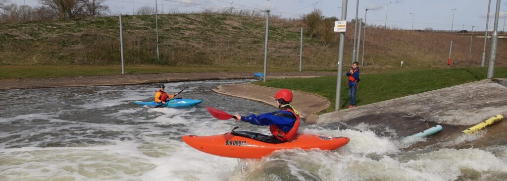 Club member launching kayak off drop at Nene whitewater centre